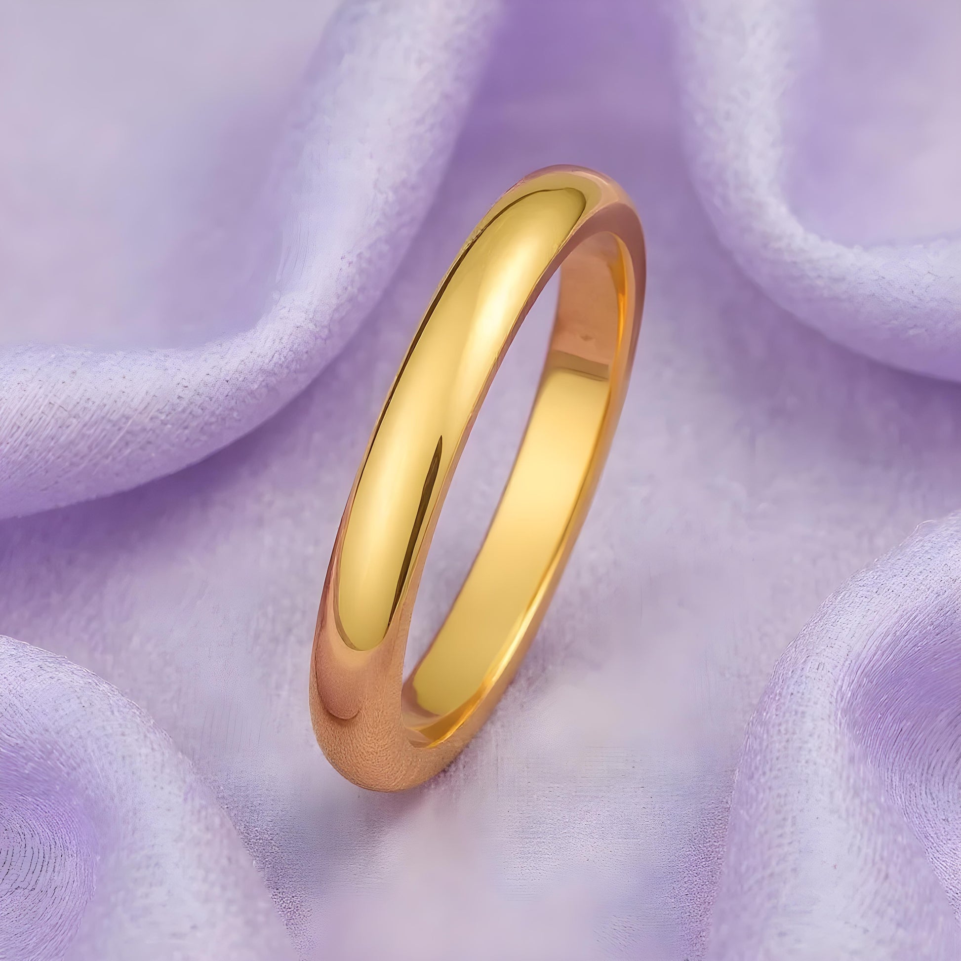 Gold ring on a soft purple fabric background